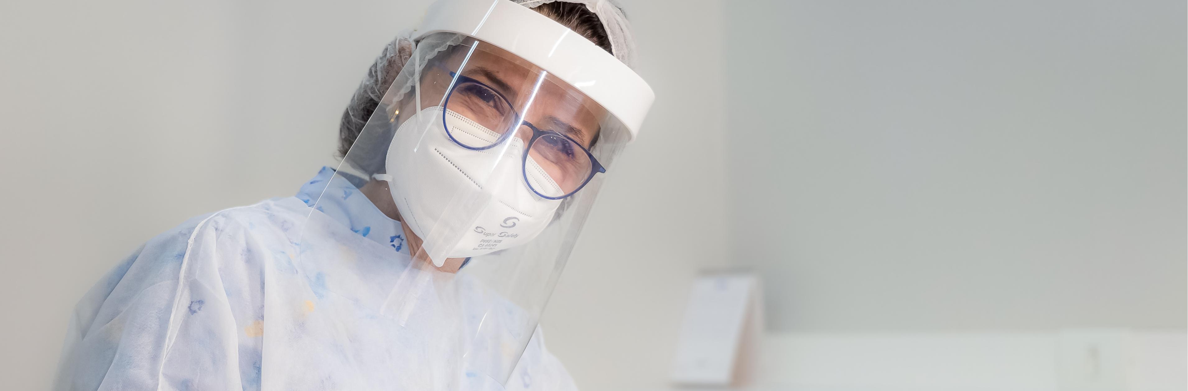 Dentista com equipamentos de proteção manuseando instrumento técnico na boca de paciente